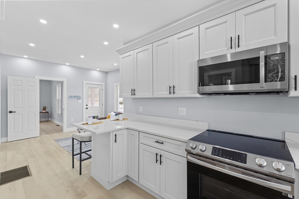 15 Bennett Street Everett, MA 02149 - Photo 8 of 39 a kitchen with a sink stainless steel appliances and white cabinets