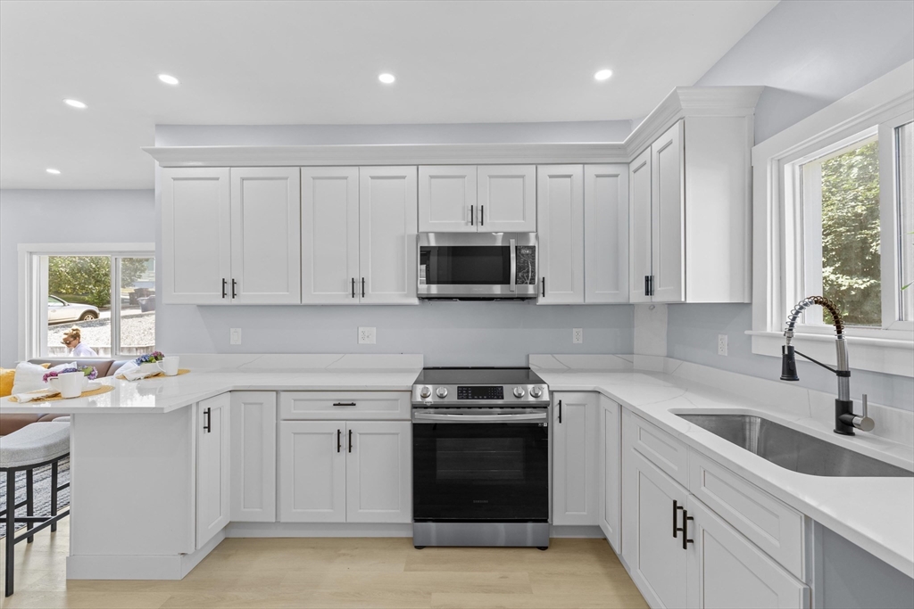 15 Bennett Street Everett, MA 02149 - Photo 9 of 39 a kitchen with white cabinets and appliances