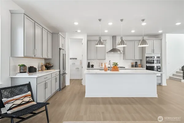 a view of kitchen with kitchen island white cabinets and stainless steel appliances