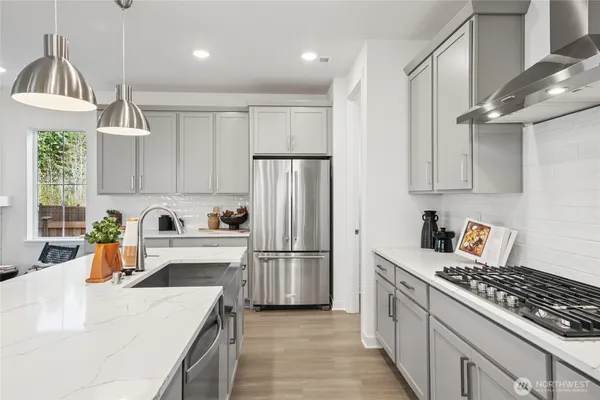 a kitchen with stainless steel appliances granite countertop a sink stove refrigerator and cabinets