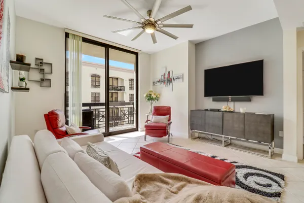 a living room with furniture a flat screen tv and a floor to ceiling window