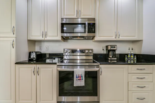a kitchen with stainless steel appliances granite countertop a stove and a microwave