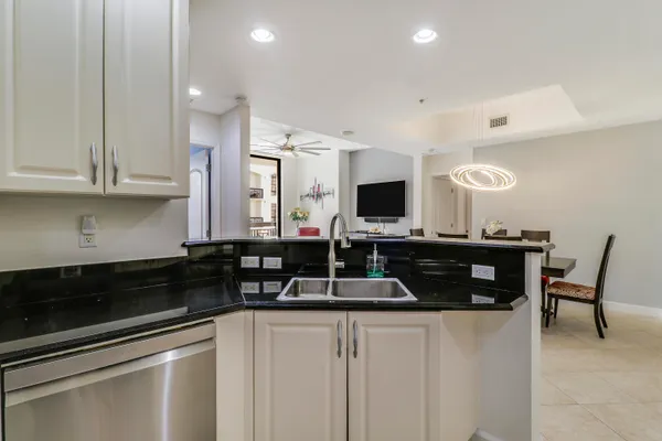 a kitchen with stainless steel appliances a stove a sink and a white cabinets