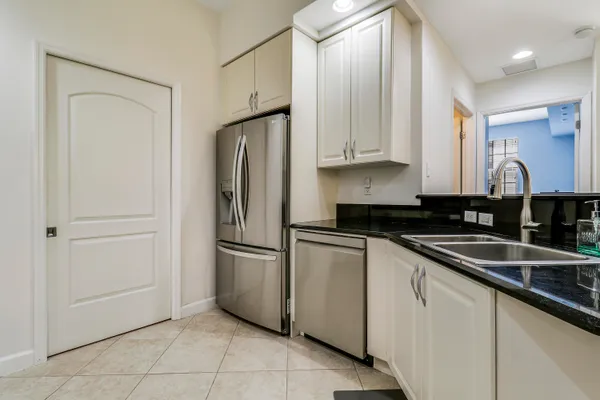 a kitchen with stainless steel appliances granite countertop a refrigerator and a sink