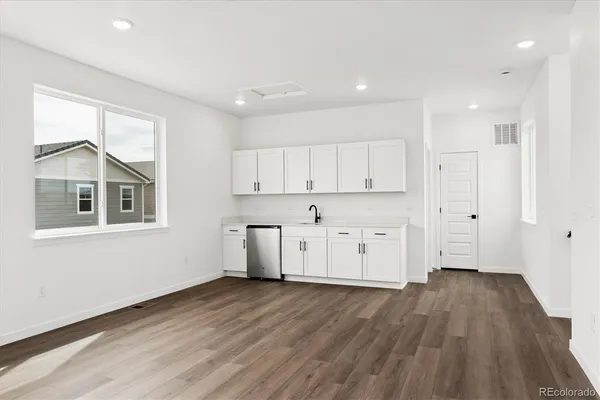 a view of a kitchen with wooden floor and a window