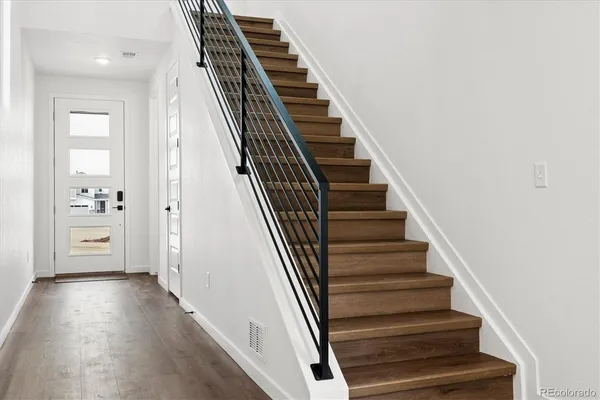 a view of a hallway with wooden floor and entryway