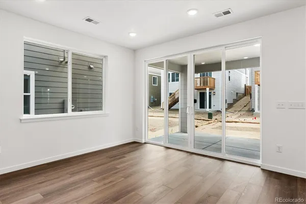 a view of a big room with wooden floor and windows