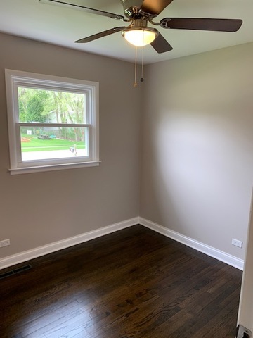 535 Willow Road Wauconda, IL 60084 - Photo 12 of 17 an empty room with wooden floor fan and windows