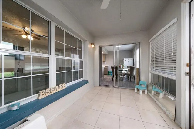a room with furniture a dining table and a large window with garden view