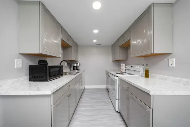 a kitchen with stainless steel appliances granite countertop a sink stove and refrigerator