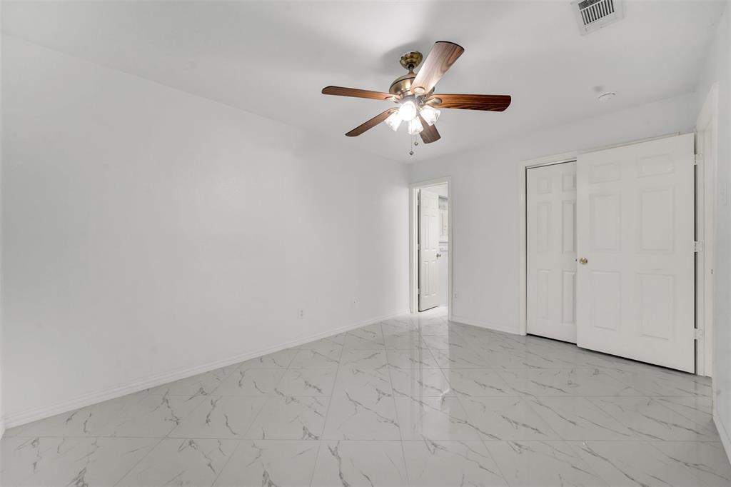 4610 Bucknell Drive Garland, TX 75042 - Photo 14 of 25 an empty room with windows and fan