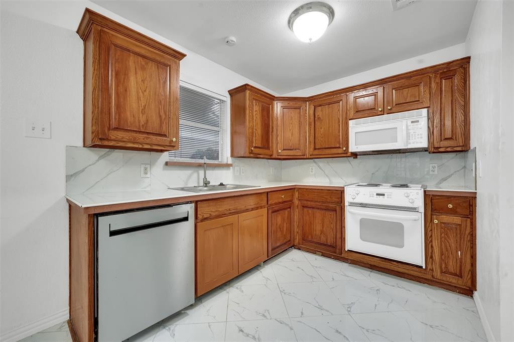 4610 Bucknell Drive Garland, TX 75042 - Photo 9 of 25 a kitchen with stainless steel appliances granite countertop a stove a sink and a microwave