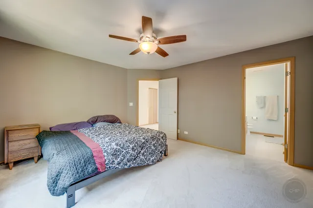a spacious bedroom with a bed and a chandelier