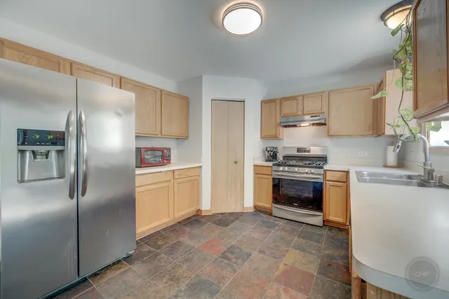 a kitchen with granite countertop a refrigerator stove and sink