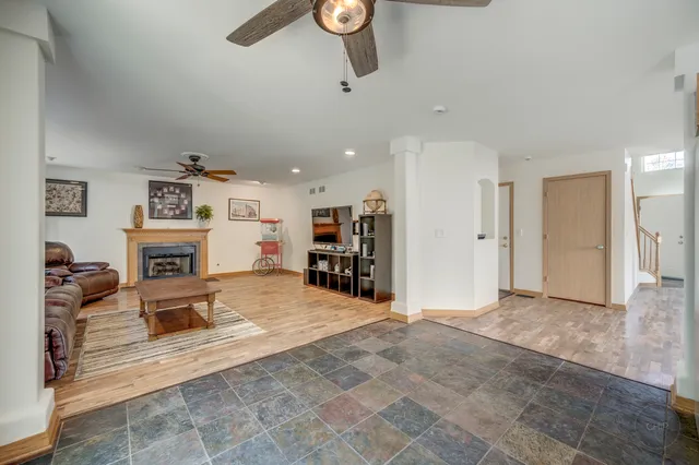 a view of a livingroom with a fireplace a chandelier a wooden table and chairs