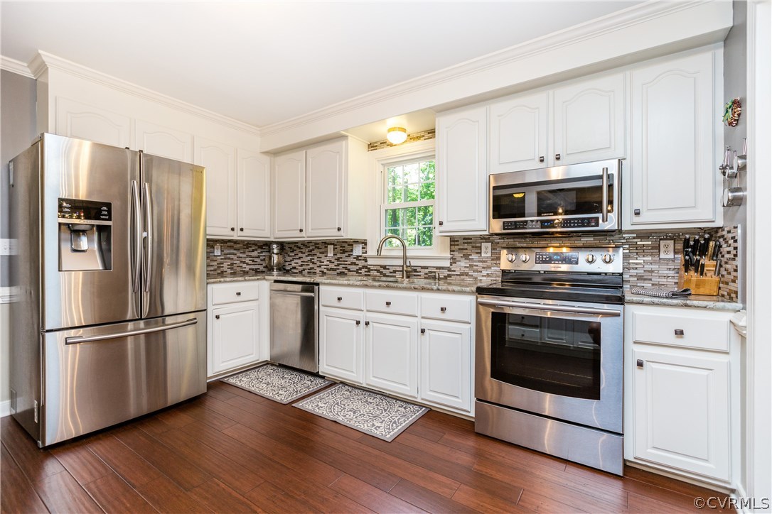 4115 Poplar Grove Road Midlothian, VA 23112 - Photo 6 of 36 a kitchen with wooden cabinets white stainless steel appliances and wooden floors