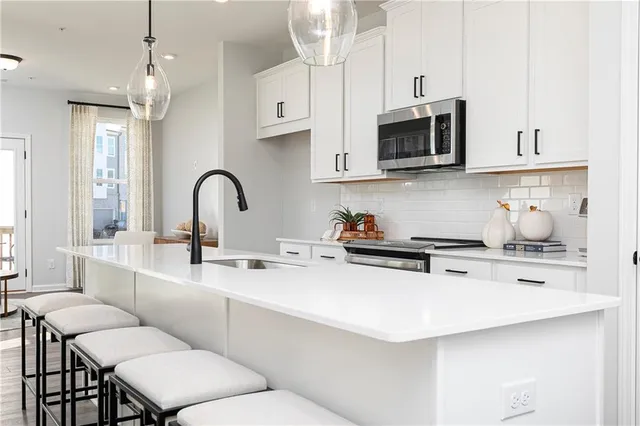 a kitchen with stainless steel appliances a sink a stove a microwave and cabinets