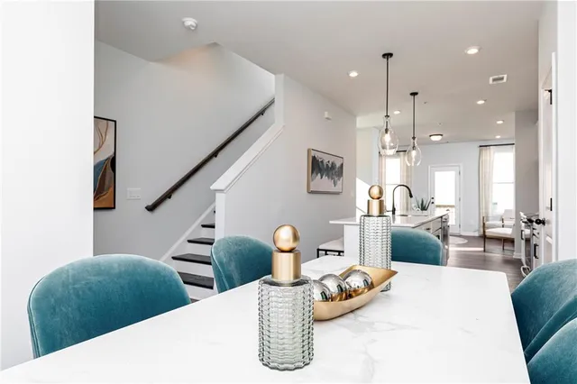 a kitchen with stainless steel appliances kitchen island granite countertop a table chairs and a refrigerator