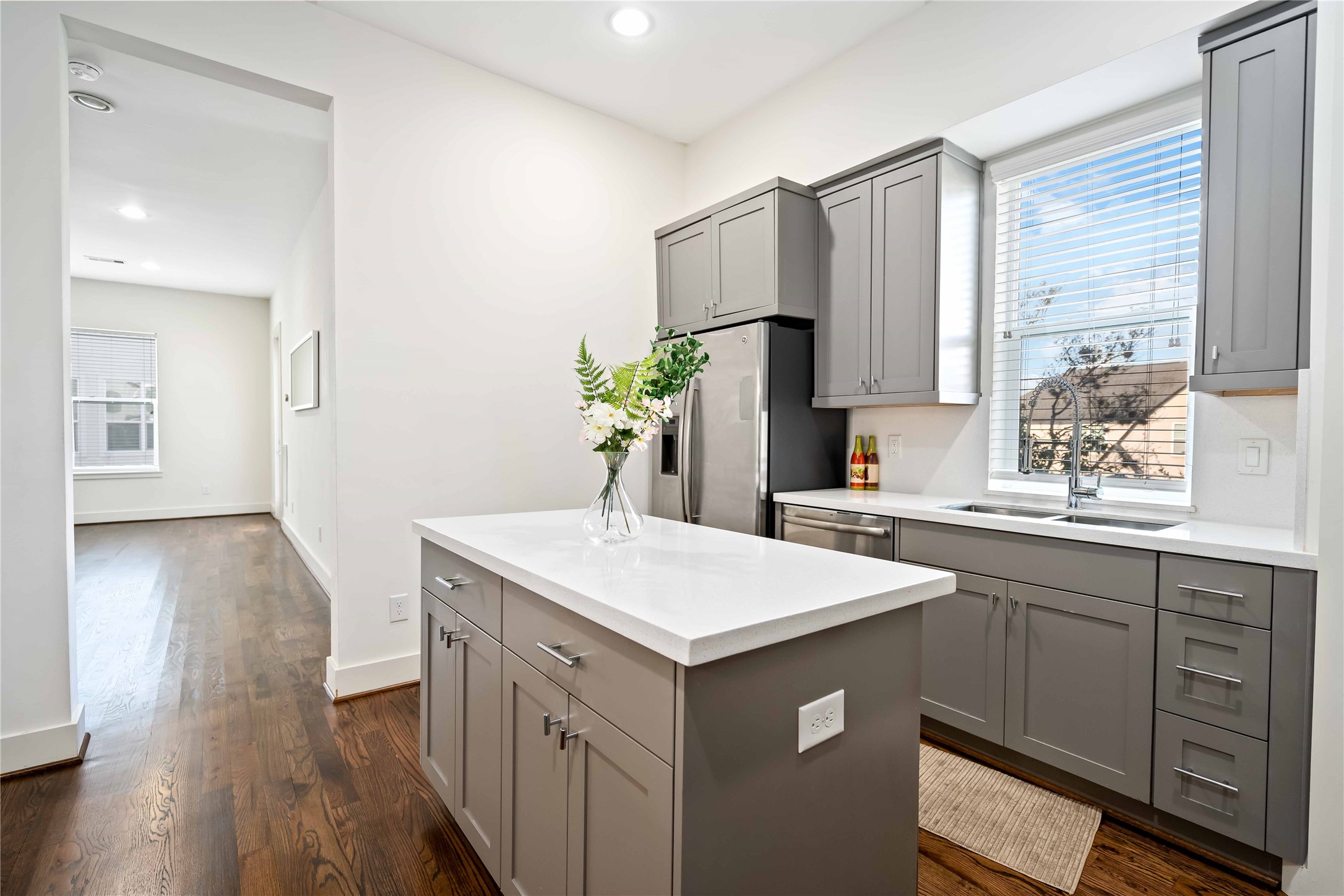 2004 Rosedale Street, Unit F Houston, TX 77004 - Photo 14 of 33 a kitchen with a sink a wooden floor and white cabinets