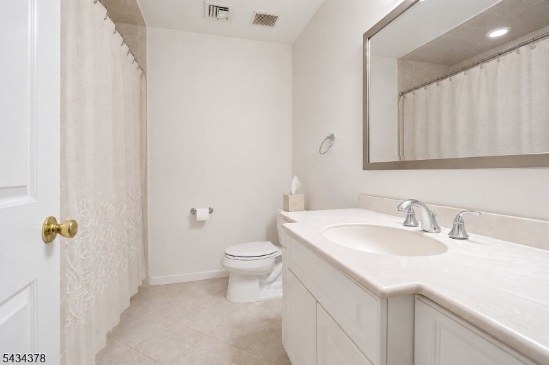 606 Park Place Springfield, NJ 07081 - Photo 16 of 21 a bathroom with a sink a toilet and mirror