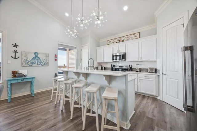 a kitchen with white cabinets stainless steel appliances and dining table