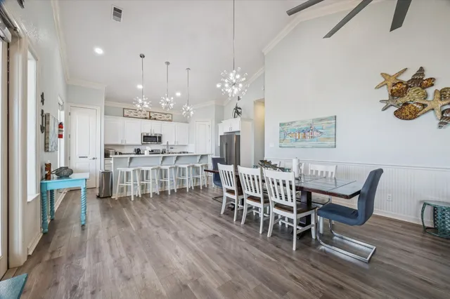 a dining room with furniture a chandelier and wooden floor