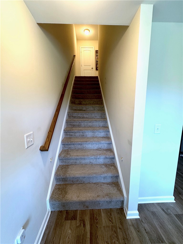 143 Adger Road Pendleton, SC 29670 - Photo 17 of 30 Carpeted stairs ascend from the wood-look flooring of the main living area.