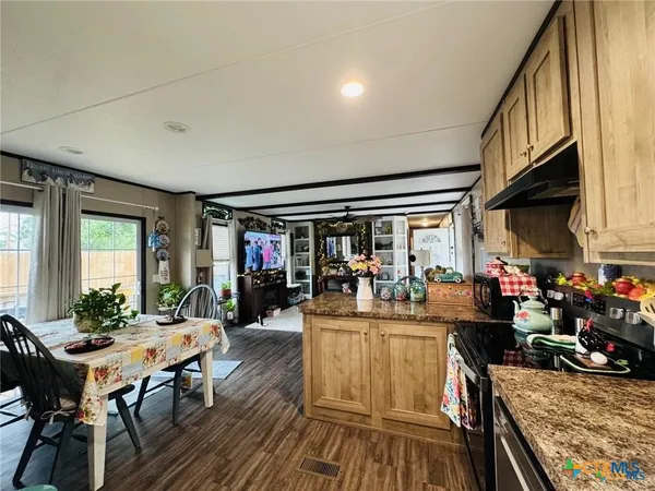 a view of a dining room with furniture one side kitchen view and a window