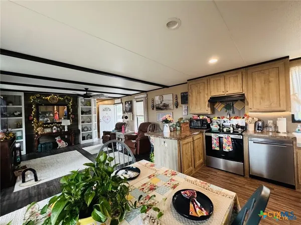 a living room with furniture and a dining table with kitchen view