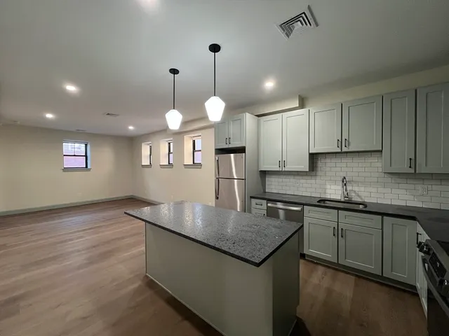 a kitchen with stainless steel appliances granite countertop stove top oven and cabinets