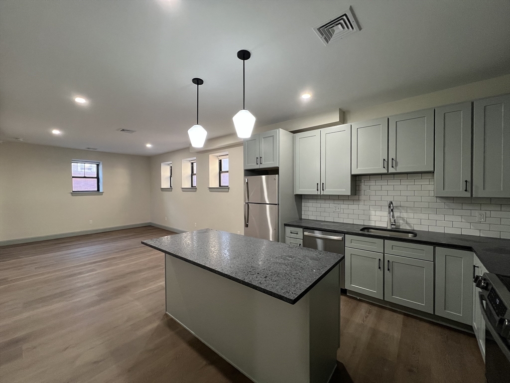 a kitchen with stainless steel appliances granite countertop stove top oven and cabinets