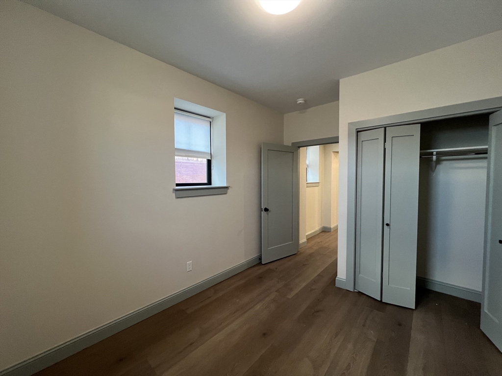 160 Seabury Street, Unit 2 Fall River, MA 02720 - Photo 4 of 11 an empty room with wooden floor closet and windows