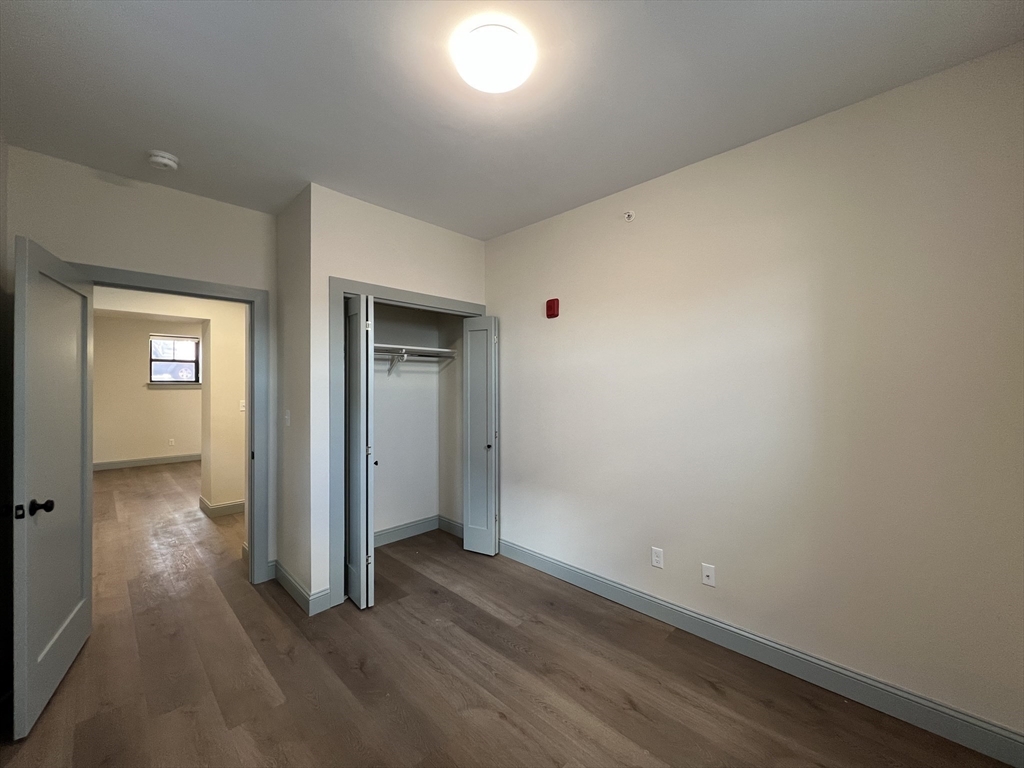 160 Seabury Street, Unit 2 Fall River, MA 02720 - Photo 9 of 11 an empty room with wooden floor and windows