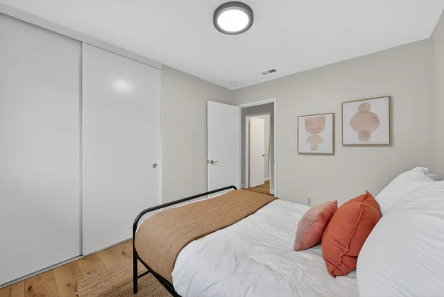 a bedroom with a bed and painting on the wall