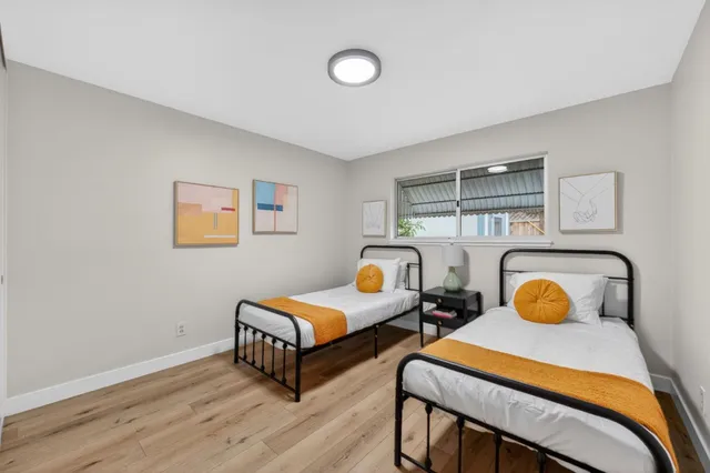 a bedroom with two beds and painting on the wall