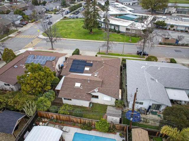 an aerial view of a house with a garden and lake view