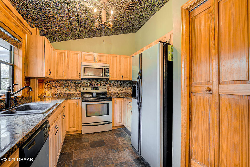 114 Pine Creek Court Ormond Beach, FL 32174 - Photo 16 of 41 a kitchen with stainless steel appliances granite countertop a refrigerator and a sink