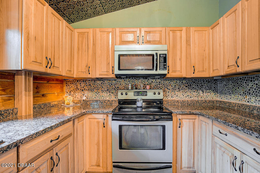 114 Pine Creek Court Ormond Beach, FL 32174 - Photo 17 of 41 a kitchen with stainless steel appliances granite countertop a stove a sink and a microwave