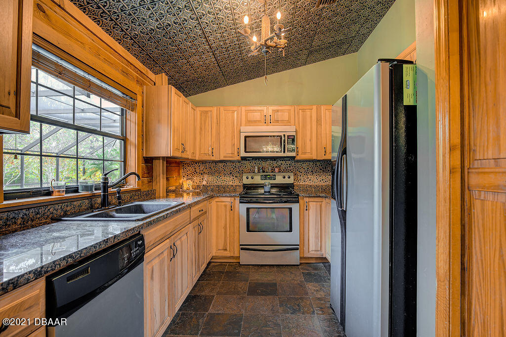 114 Pine Creek Court Ormond Beach, FL 32174 - Photo 18 of 41 a kitchen with stainless steel appliances granite countertop a sink and a stove