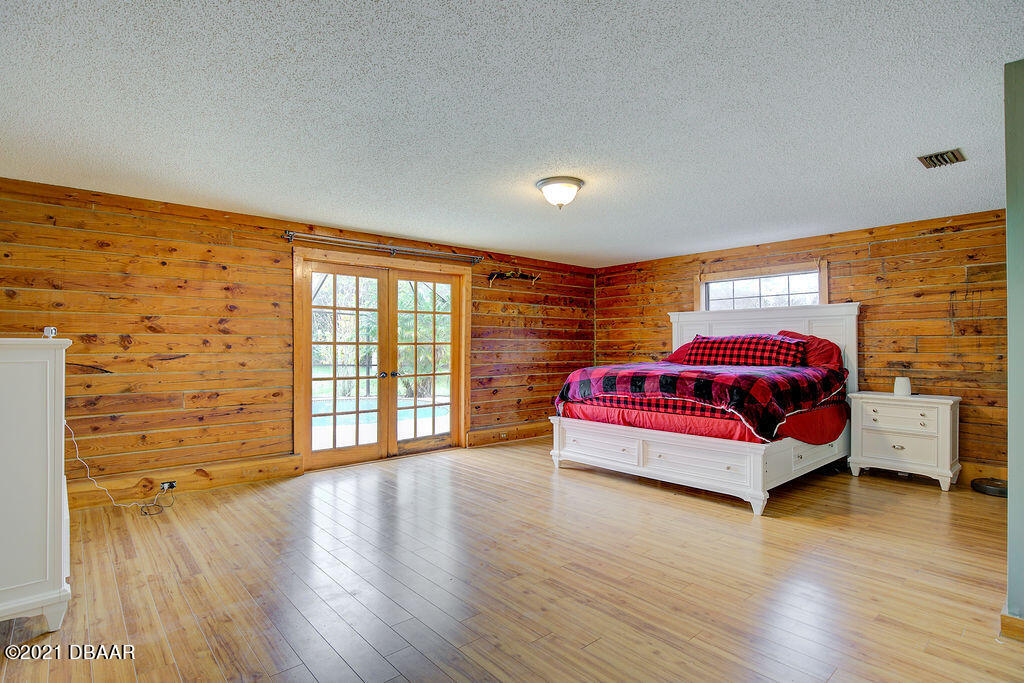114 Pine Creek Court Ormond Beach, FL 32174 - Photo 20 of 41 a bedroom with a bed and wooden floor