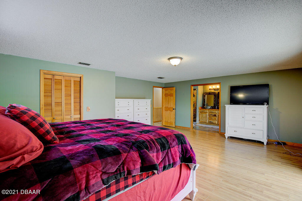 114 Pine Creek Court Ormond Beach, FL 32174 - Photo 21 of 41 a bedroom with a bed and wooden floor
