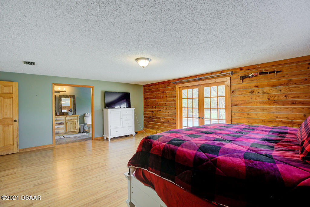 114 Pine Creek Court Ormond Beach, FL 32174 - Photo 23 of 41 a bedroom with a bed and wooden floor