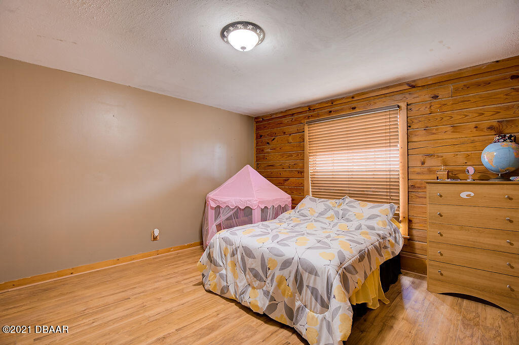 114 Pine Creek Court Ormond Beach, FL 32174 - Photo 28 of 41 a bedroom with a bed and wooden floor