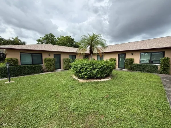 a front view of a house with a yard and potted plants