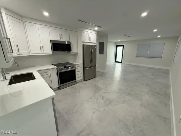a kitchen with stainless steel appliances a refrigerator sink and microwave