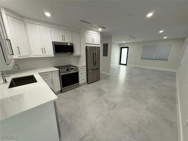 a kitchen with stainless steel appliances a refrigerator sink and microwave