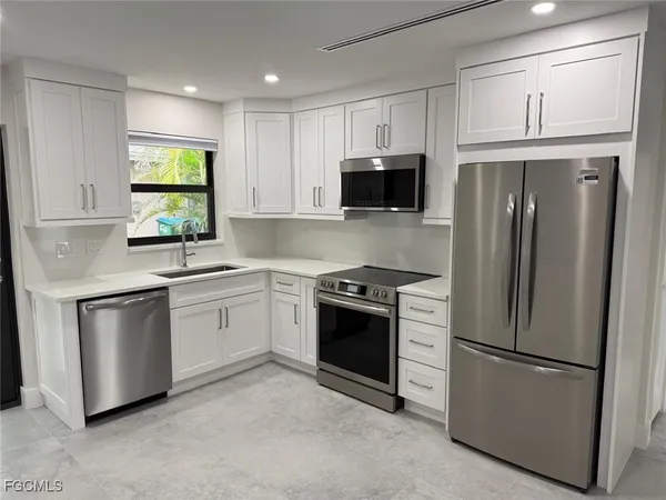 a kitchen with stainless steel appliances a refrigerator sink and microwave