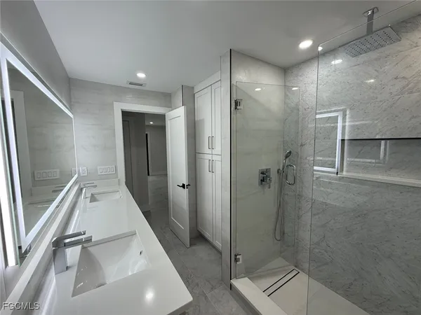 a bathroom with a double vanity sink mirror and tub