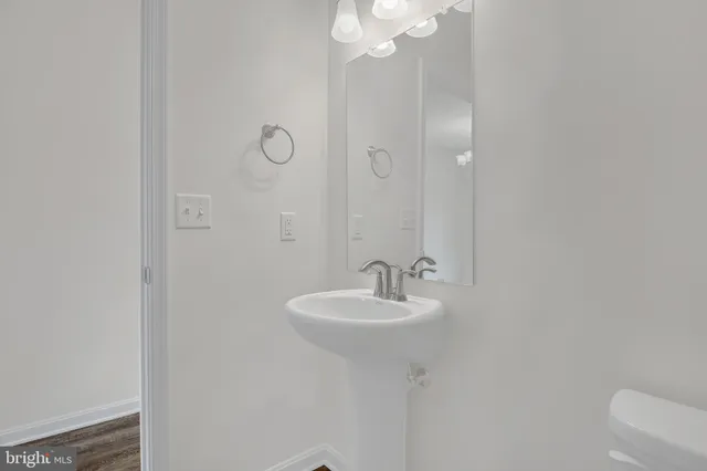 a bathroom with a sink a toilet and a mirror