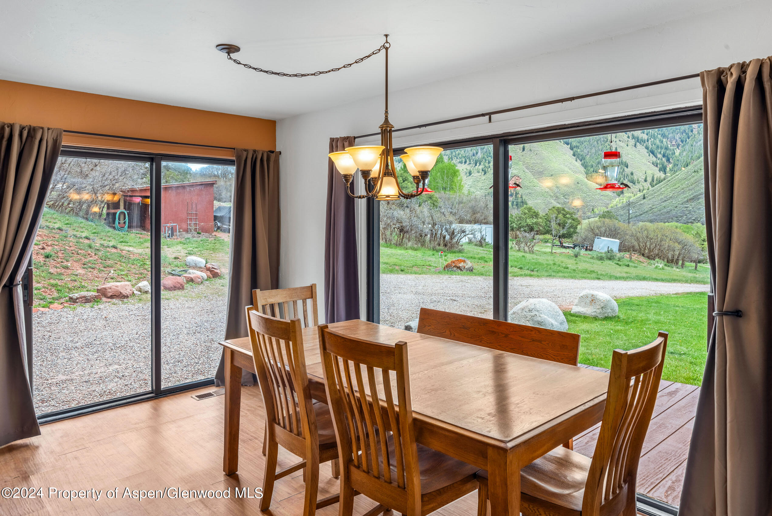 299 Knight Road Basalt, CO 81621 - Photo 13 of 48 a view of a dining room with furniture large windows and wooden floor